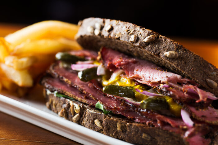 Delicious pastrami sandwich with french fries ready to eat.