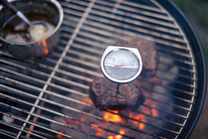 Delicious steak and ribeye barbecued stock photo. The sauce is spread over the meat. Fires are coming out from under the grill