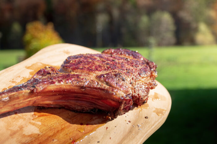 Dry Aged Barbecue Tomahawk Steak on wooden plate