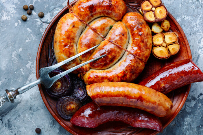 Food tray with delicious sausages and fresh salami