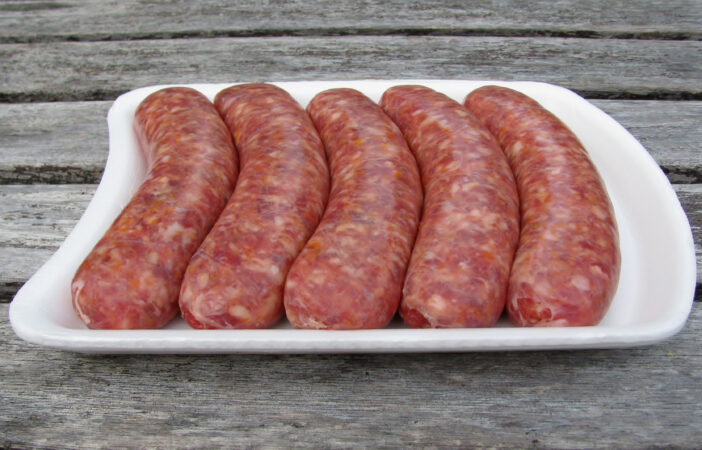 Fresh raw sausages on white styrofoam tray