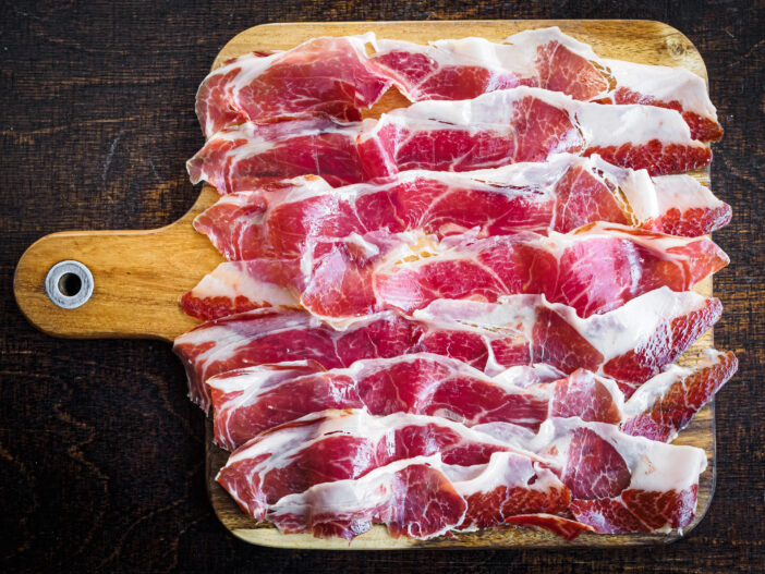 Iberico ham cut on a wooden board, spanish typical tapa