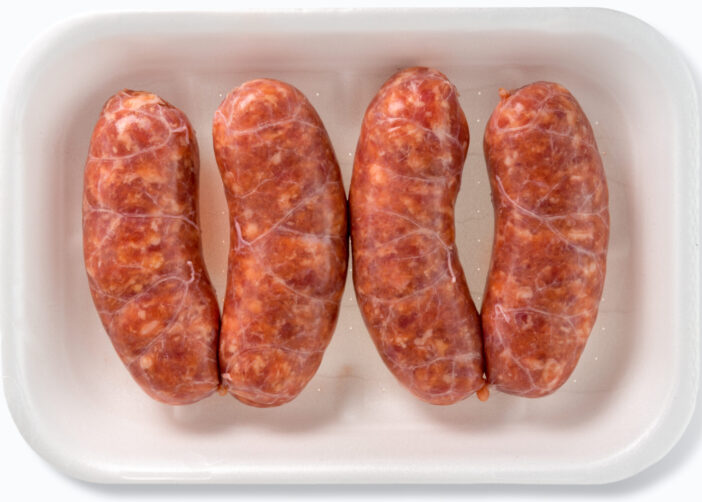 Italian salamella sausage in plastic food tray for sale in the market isolated on white in top view