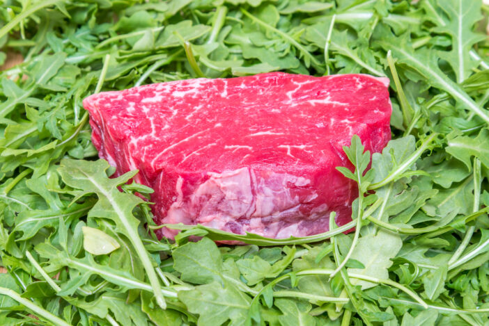 Piece of beef fillet in a baby arugula