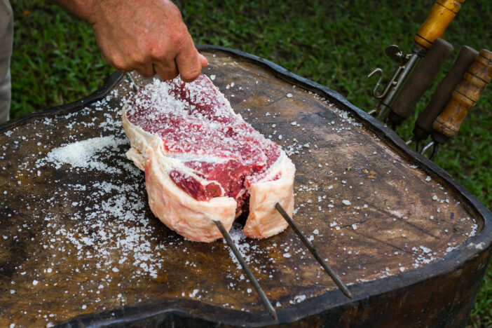 Piece of meat being salted in a southern Brazilian way of preparing a barbecue