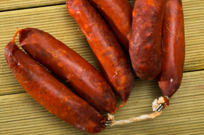 Popular Spanish smoked pork sausages chorizo on wooden surface