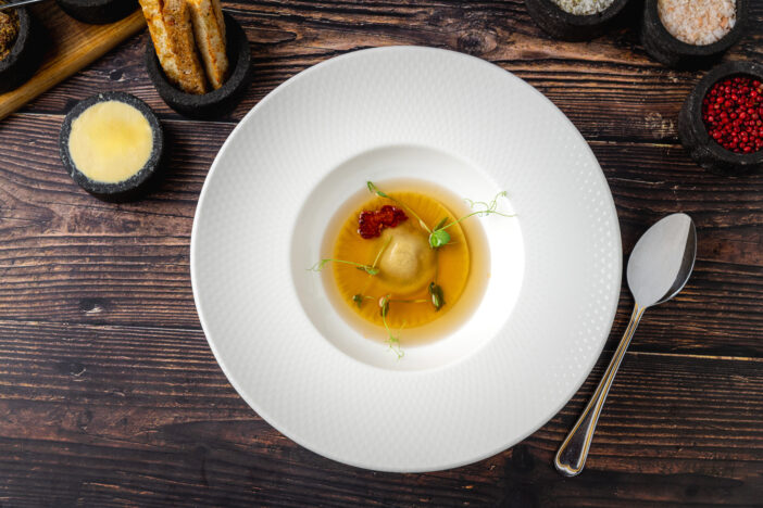 Ravioli consomme on a white porcelain plate. Healthy eating concept