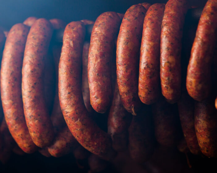 Traditional food. Smoked sausages meat hanging in domestic smokehouse.