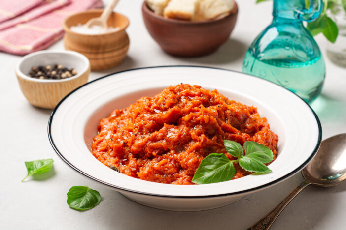 Pappa al Pomodoro. Tuscan bread soup with tomatoes, olive oil and basil in plate on concrete background. Traditional italian dish. Selective focus.