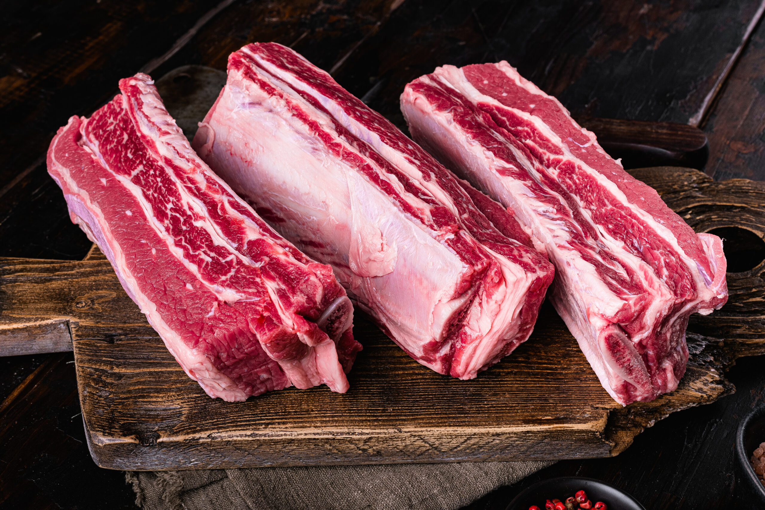 Raw Organic Beef Short Ribs, on old dark  wooden table background.