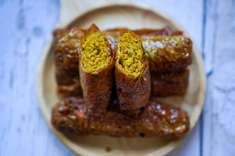 Close-up image of a spiced vegetarian sausage menu made from plant-based protein on a wooden plate.