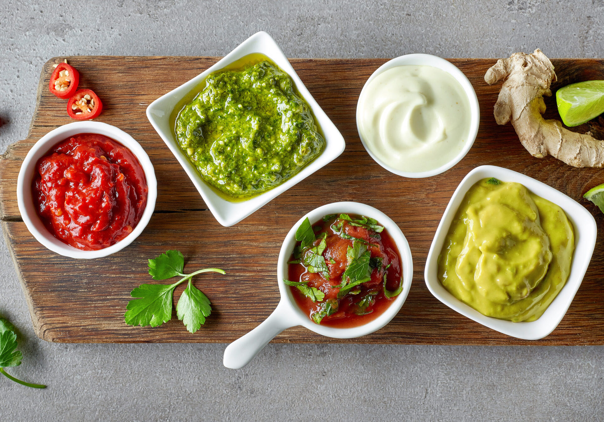 various dip sauces on grey table, top view