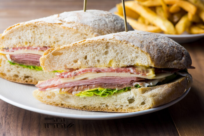 Panini or Italian Grilled pressed sandwich. Classic Italian lunch favorite, sandwiches w/ deli meats, salami, prosciutto, cheeses, mozzarella, Parmesan, roasted veggies, sun-dried tomatoes, arugula, sautéed mushrooms on sourdough bread.
