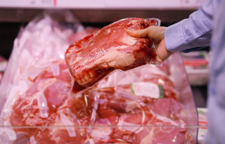 man purchasing a packet of meat at the supermarket