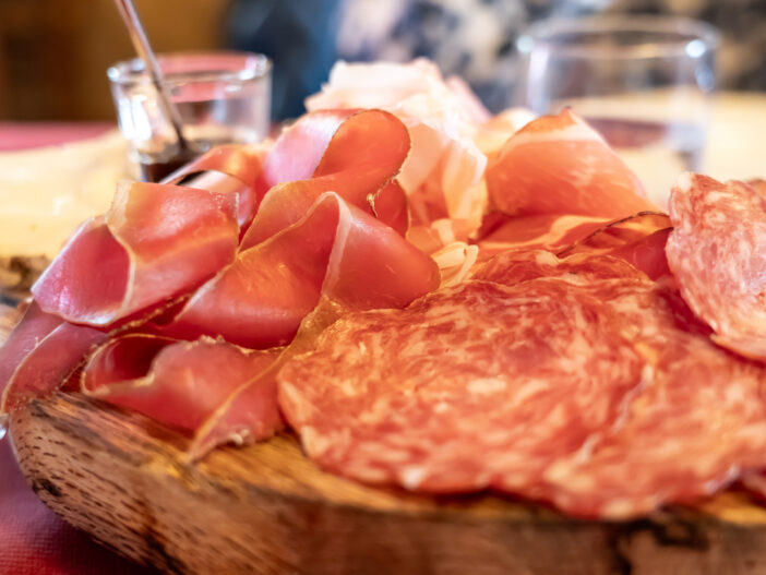 Delicious cutting board of fresh cold cuts. Bacon, coppa, salami. Traditional Italian dish