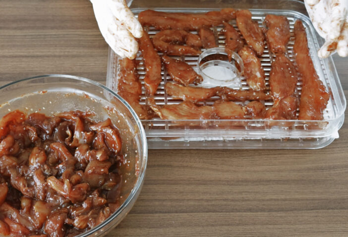 Home cooking Chicken slices while dehydrating making jerky in Dehydrator.