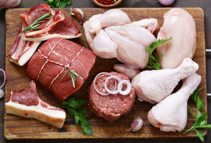 raw meat assortment - beef, lamb, chicken on a wooden board