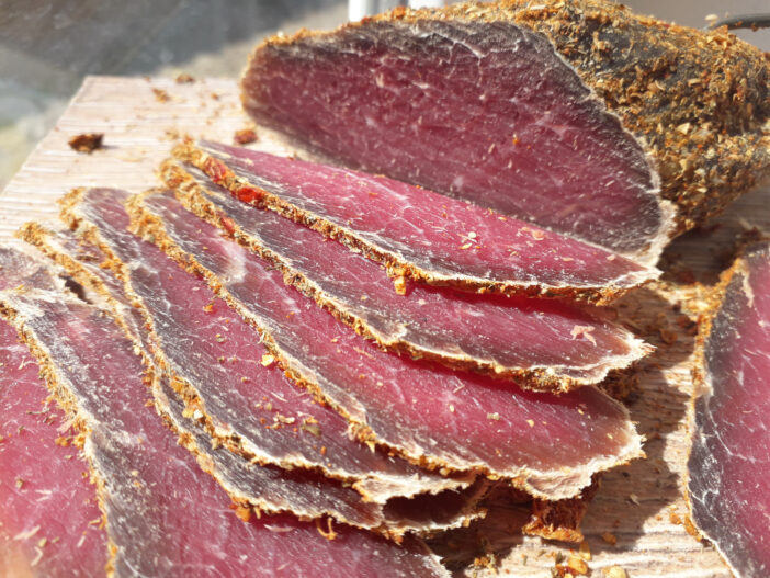 A closeup shot of homemade pastrami sliced on a cutting board