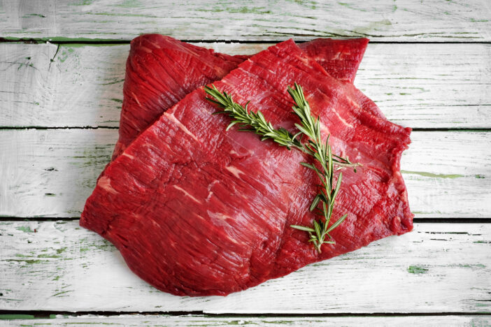 raw fillet of beef brisket on white wooden background