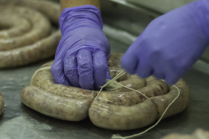 Tying the sausage in a natural casing. Sausage factory