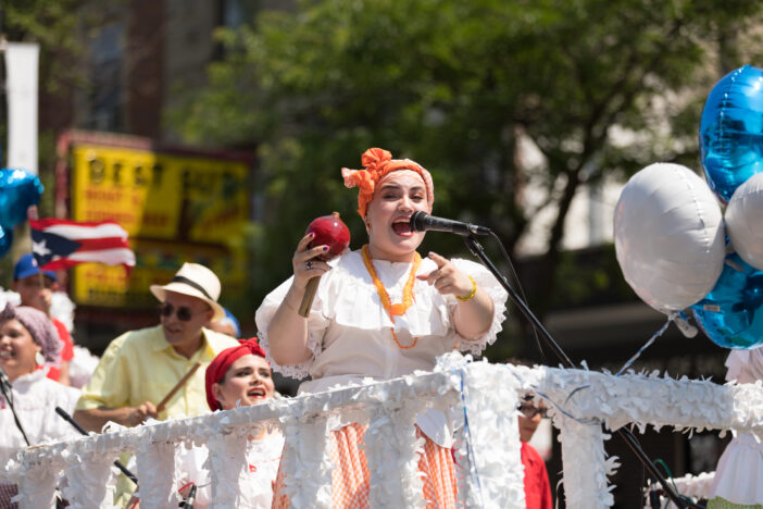 Chicago, Illinois, USA - June 16, 2018: The Puerto Rican People's Parade, woman wearing traditional puerto rican clothing singing on a float