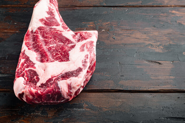 Dry aged raw tomahawk beef steak with ingredients for grilling set, on old dark  wooden table background, with copy space for text