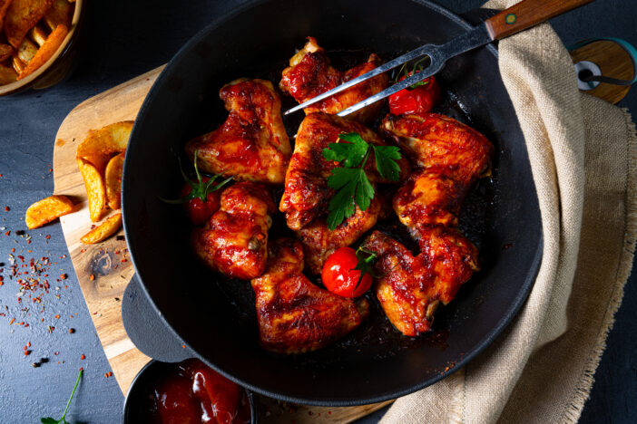 Spicy chicken wings in honey with potato wedges