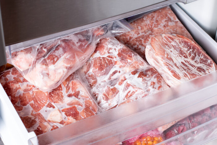 Raw frozen meat. Raw pork chops in the freezer. Frozen food