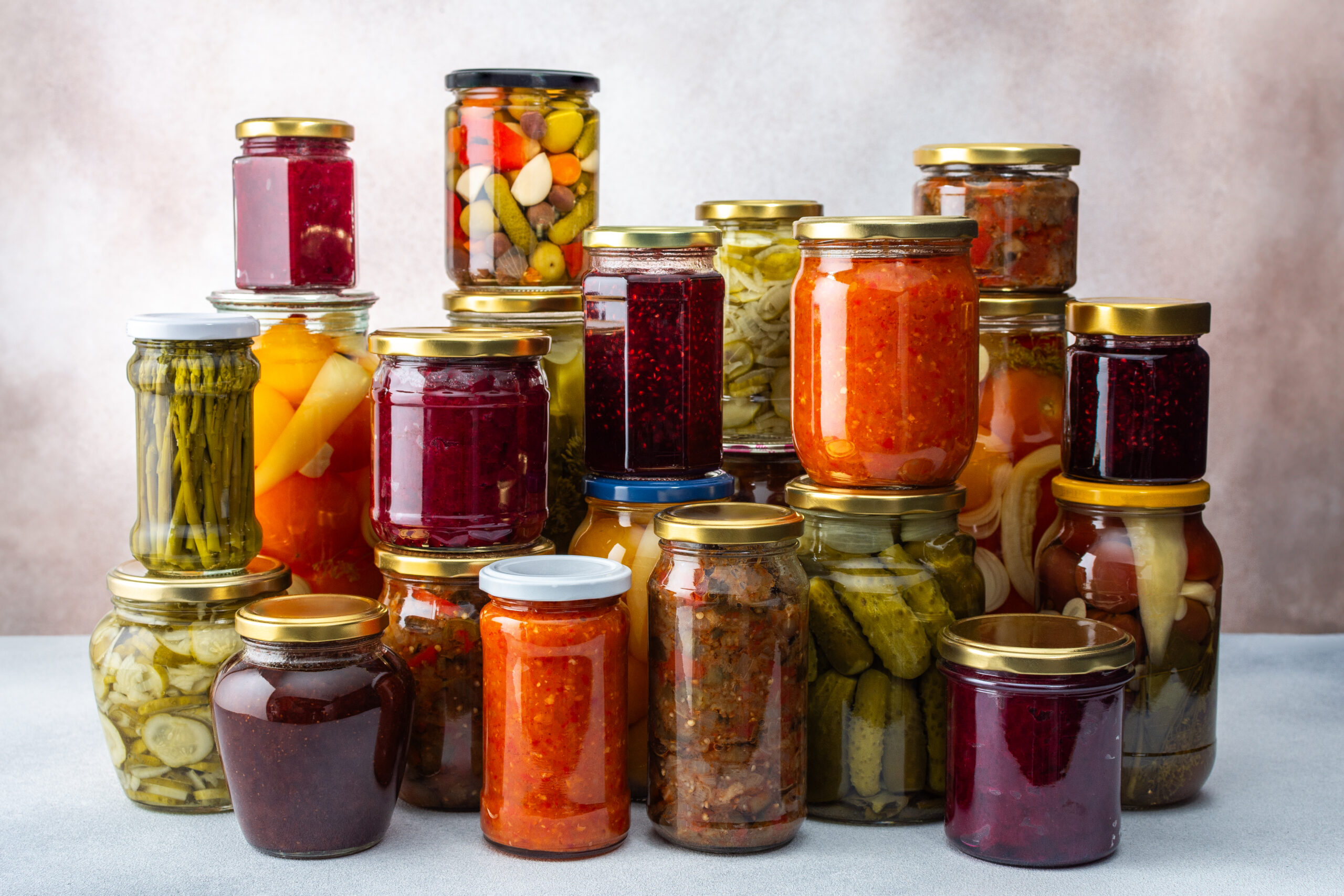 Preserving vegetables for the winter, a lot of glass jars with canned vegetables and adjika, jam and vegetable salads, pickled or fermented vegetables, copy space