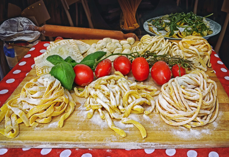 A summer  dinner .Pasta , pizza  and homemade food arrangement outside a restaurant in Rome  .Tasty and authentic Italian food ,Italy