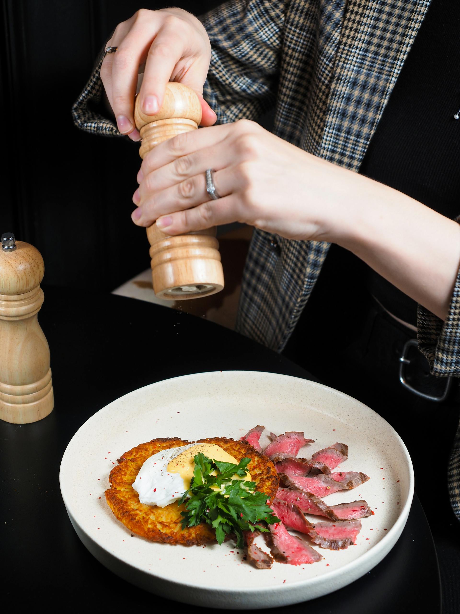 Close-up of Woman Seasoning a Dish