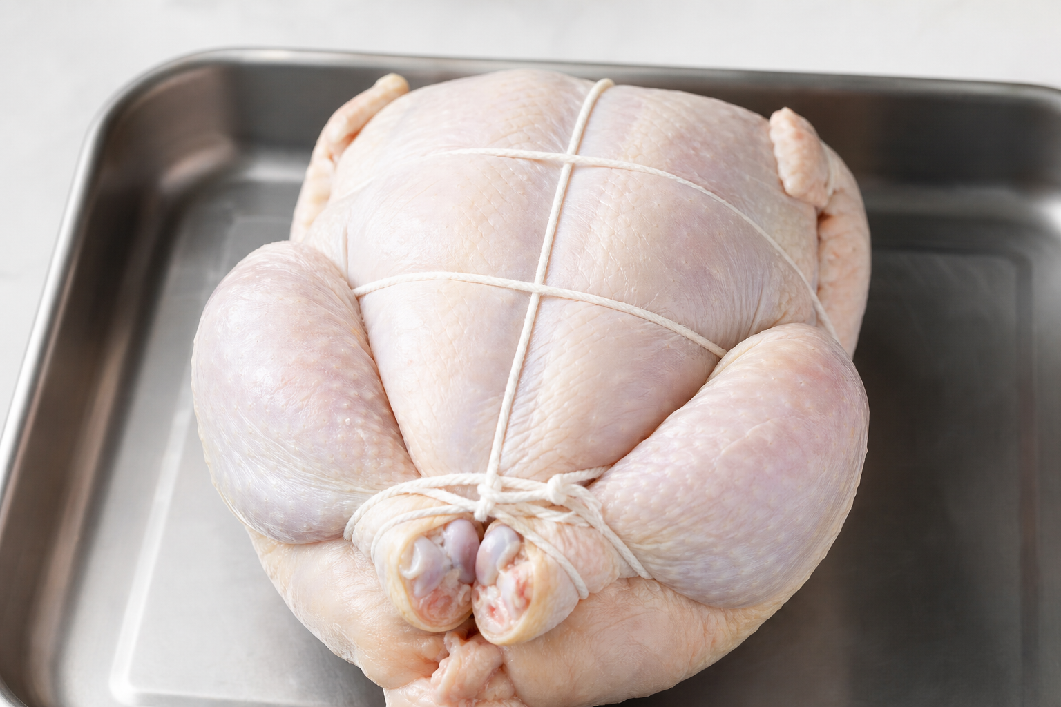 5 Techniques for Perfectly Roasted Whole Chicken 9 Whole chicken properly trussed with kitchen twine before roasting