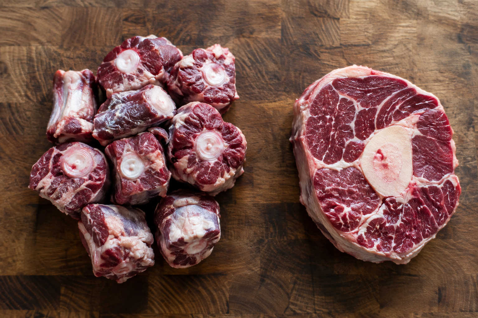Oxtail vs Beef Shank: Which Gives You More Meat for a Braise? 6 Raw oxtail pieces next to a beef shank cross-cut showing bone and meat proportions
